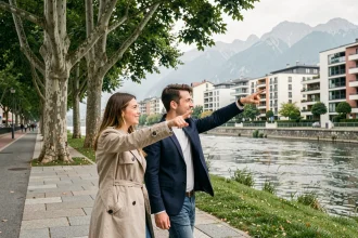 Couple de jeunes cadres se promenant sur les bords de l'Isère dans le quartier Île Verte à Grenoble, avec les montagnes en arrière-plan